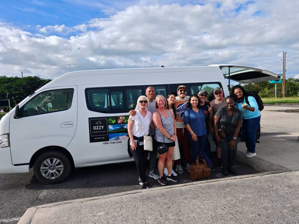 Travelers beside an Ozzy Transportation van